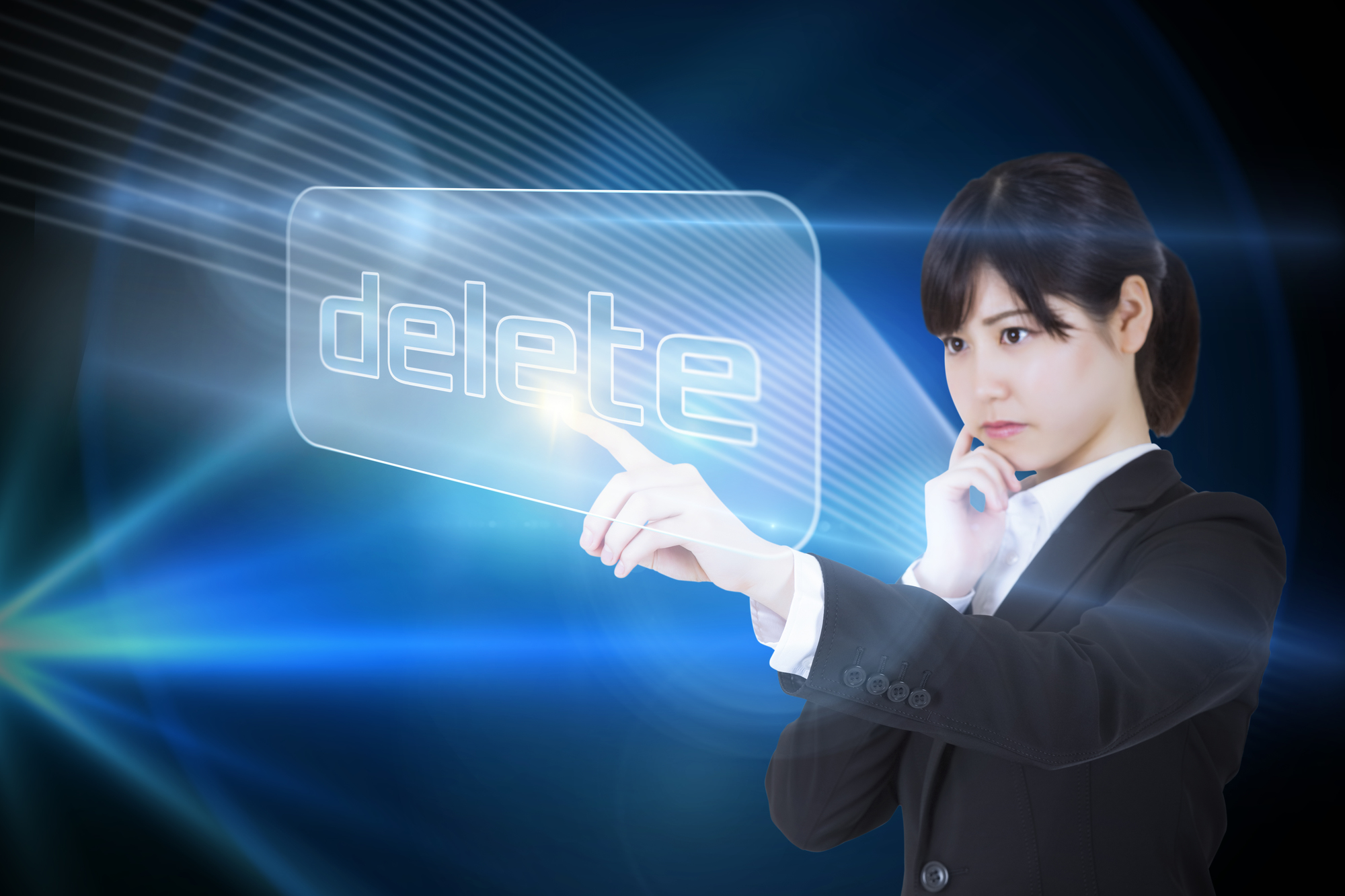 Businesswoman pointing to word delete against shiny lines on black background