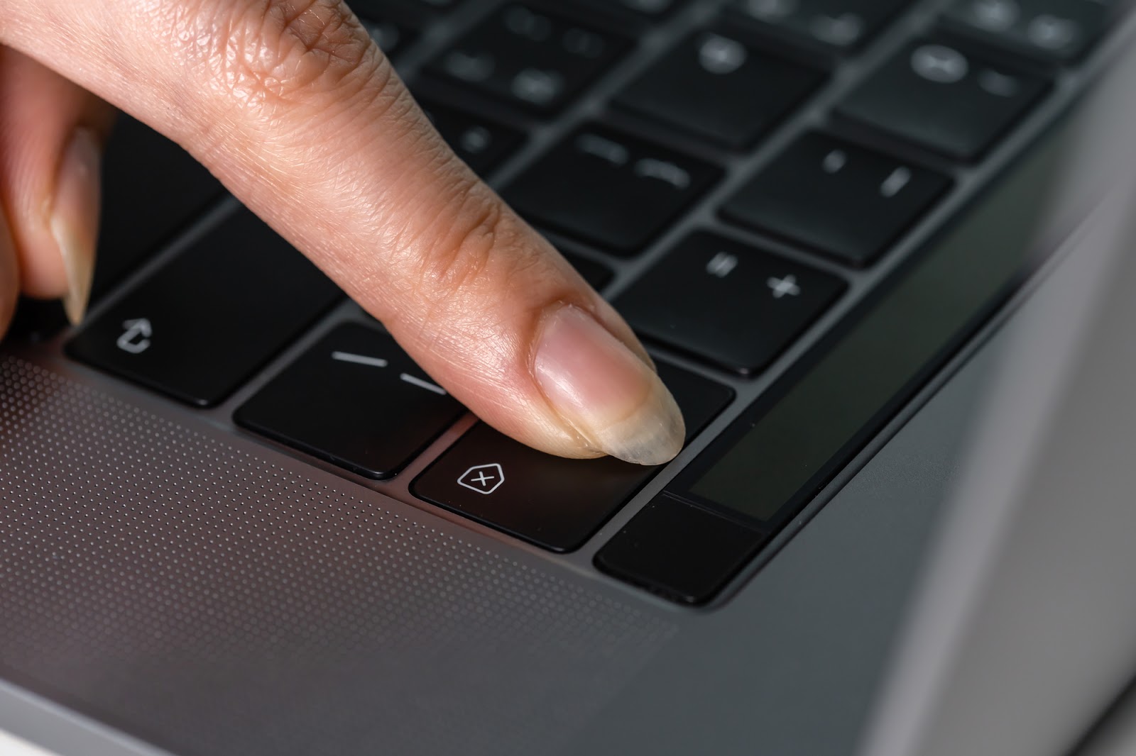 close-up female hand pressing a Backspace key for delete on a laptop keyboard